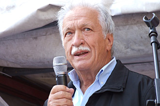 Ernst Grube hält ein Mikrofon und spricht.