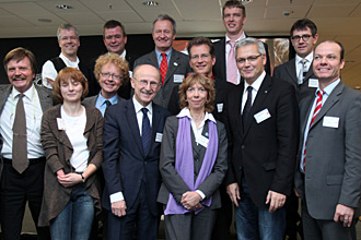 Eine Gruppe von rund 15 Personen steht für ein Gruppenfoto zusammen. Sie nehmen an einem Symposium der DFL Stiftung teil.