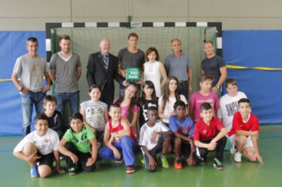 Eine Gruppe von Kindern und Jugendlichen posiert vor einem Fußballtor mit Niklas Stark, Fußballspieler von Hertha BSC, und weiteren Erwachsenen. Im Hintergrund ist eine blaue Wand zu sehen.