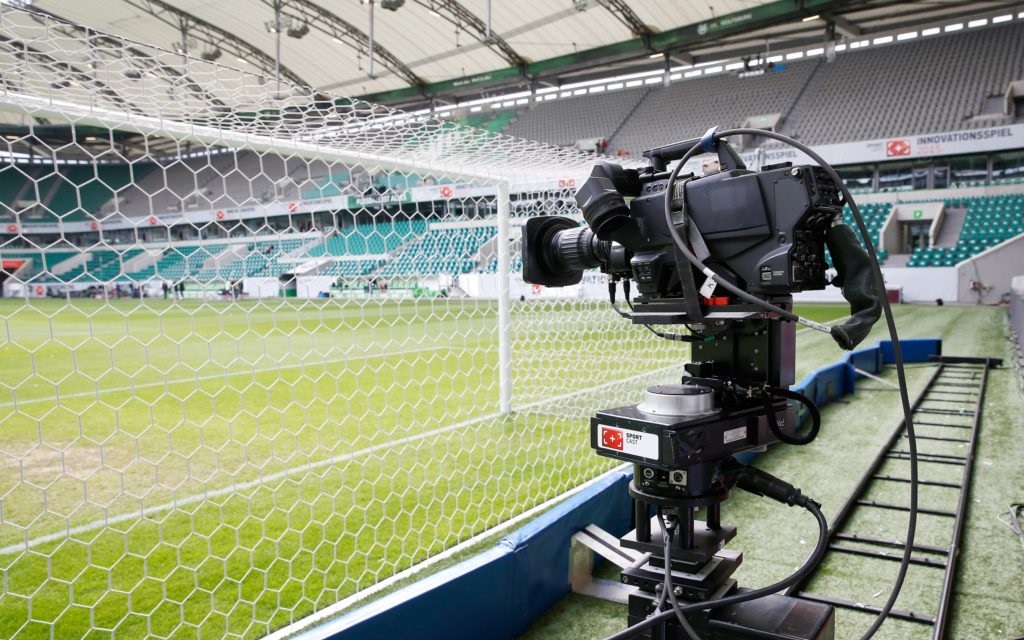 Professionelle TV-Kamera auf einer stabilen Vorrichtung vor dem Fußballfeld im Stadion während des Sportcast Innovation Days in Wolfsburg.