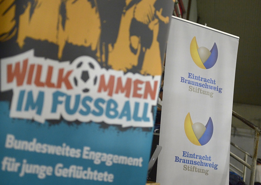 Fußballturnier "Willkommen im Fußball" mit Banner und Logo der Eintracht Braunschweig Stiftung.