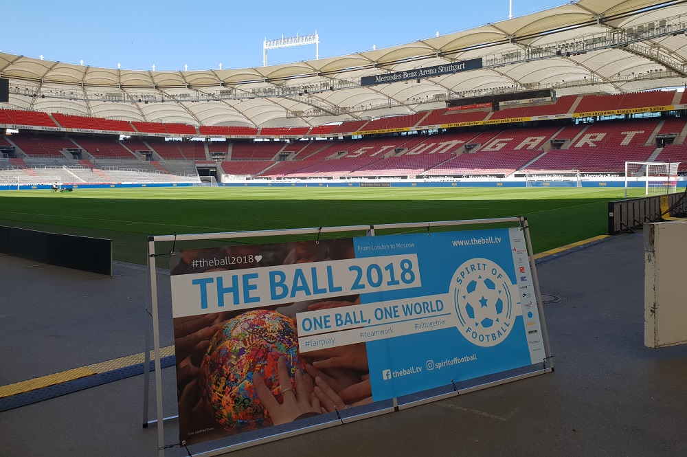 Fußballstadion mit Banner "The Ball 2018 - One Ball, One World" im Vordergrund.
