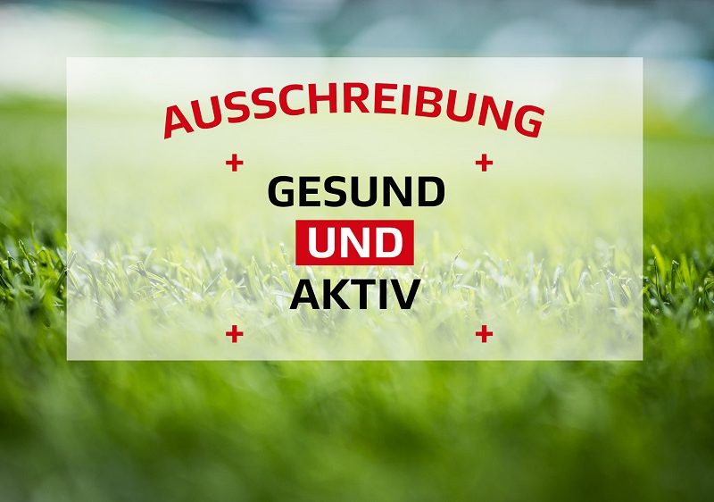 "Bild eines Fußballrasens mit einem weißen Rahmen, der die Aufschrift 'AUSSCHREIBUNG' und darunter 'GESUND UND AKTIV' in roten Buchstaben trägt. Im unteren rechten Eck befindet sich das Logo der DFL Stiftung."