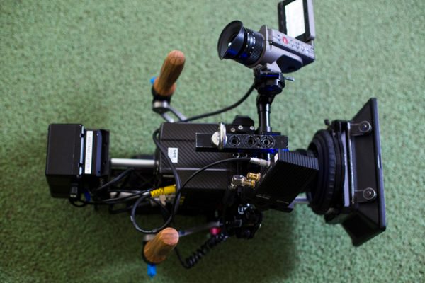 Professionelle Filmkamera auf einem grünen Untergrund, vermutlich im Stadion oder auf dem Trainingsplatz.