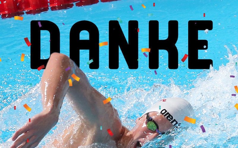 Ein Schwimmer mit Badekappe und Schwimmbrille zieht im blauen Schwimmbecken Kraulbahn. Über dem Bild steht in großen schwarzen Buchstaben das Wort "DANKE". Konfetti fliegt durch das Bild.
