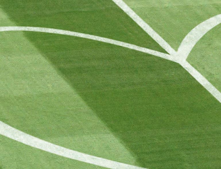 Grüner Rasen eines Fußballstadions mit einer weißen Herzform als Markierung, Symbolbild für die Arbeit der Bundesliga Stiftung.