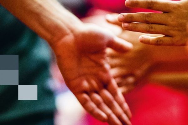 Hände reichen sich im Rahmen eines Fußballspiels oder einer Veranstaltung.