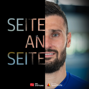 Daniel Caliguiri, Fußballspieler, blickt selbstbewusst in die Kamera. Links im Bild steht der Schriftzug "Seite an Seite" vor einem dunklen Hintergrund. Im unteren Bereich sind das Logo der Bundesliga Stiftung und das Logo von "Sporthelden" zu sehen.