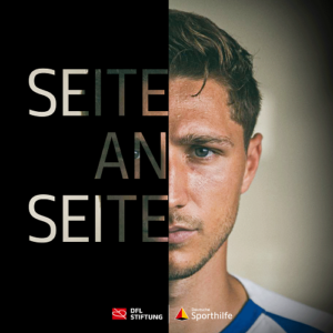Niklas Stark, Fußballspieler, im Porträt. Die linke Bildseite ist schwarz mit dem weißen Schriftzug "SEITE AN SEITE", die rechte zeigt den Kopf des Spielers. Im unteren Bereich sind das Logo der Bundesliga Stiftung und von Deutsche Sporthilfe zu sehen.