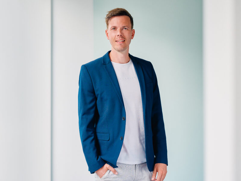 Max Türck, lächelnder Mann in blauem Sakko und weißem T-Shirt, Porträt.