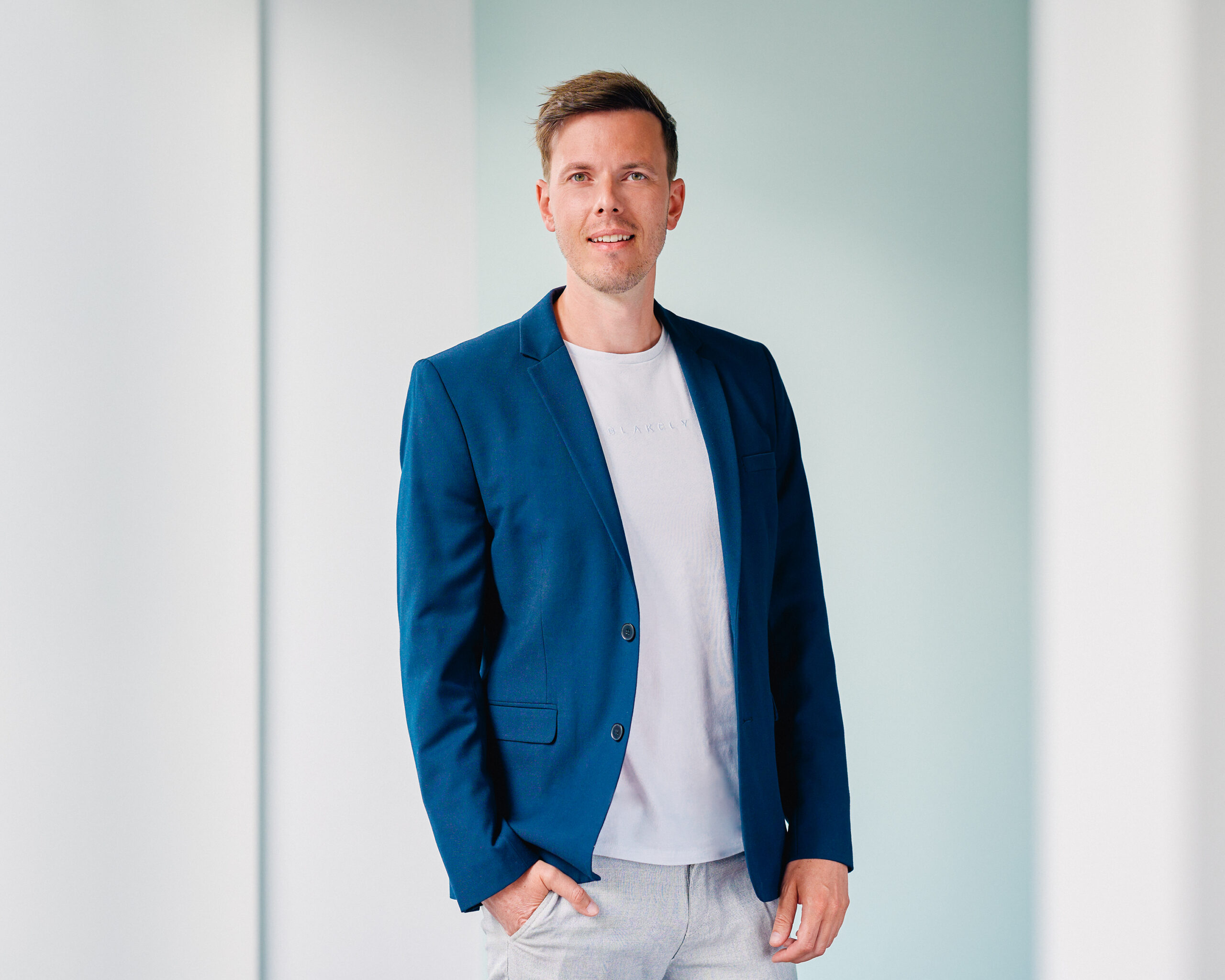 Max Türck, lächelnder Mann in blauem Sakko und weißem T-Shirt, Porträt.