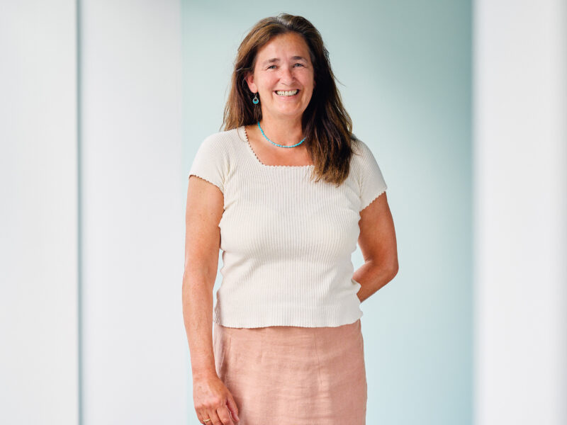 Clarissa Sagerer-Schlockermann, lächelnde Frau mit langen braunen Haaren und weißem Top.