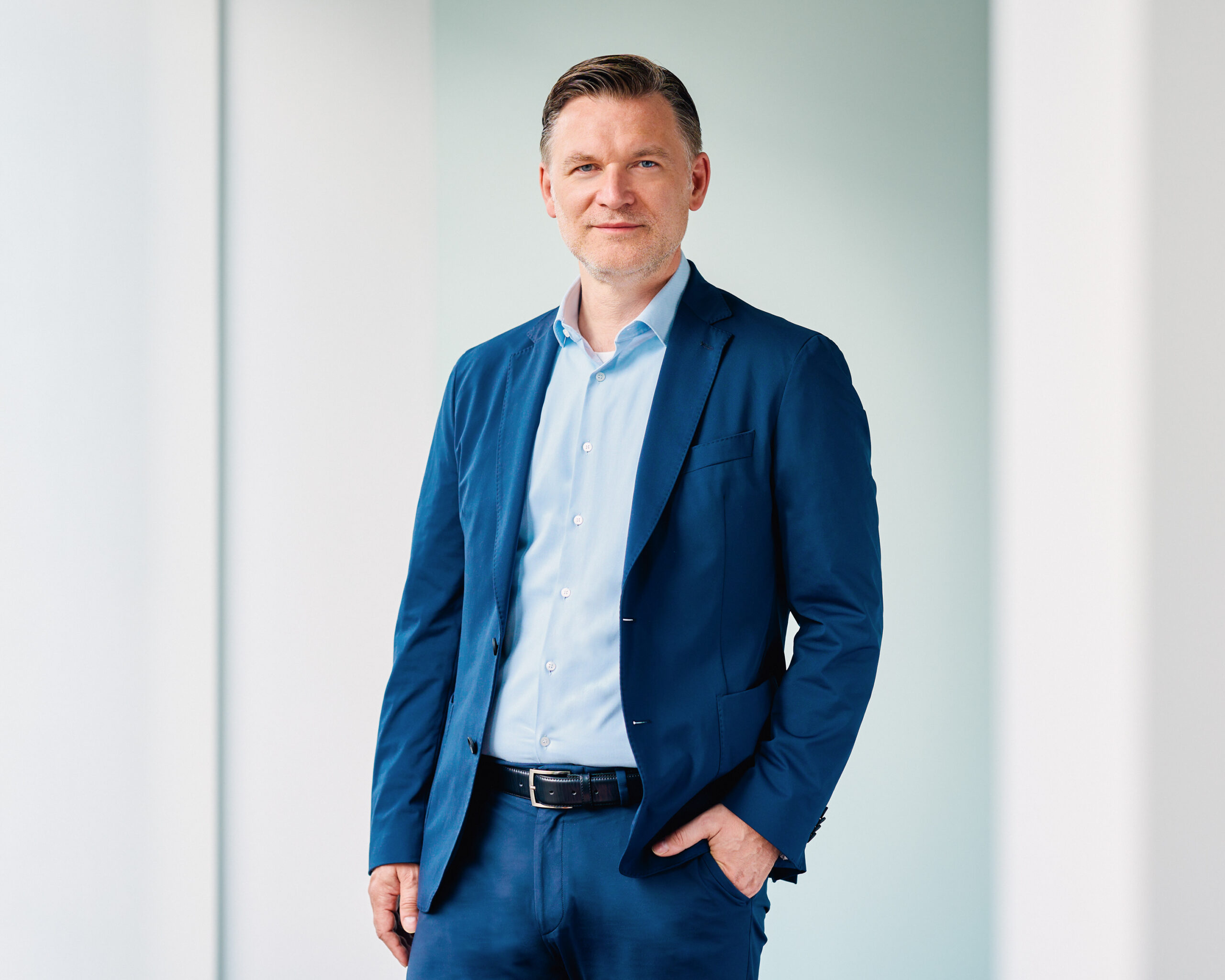 Jörg Degenhart, Mann in blauem Anzug mit Hemd, Porträt.