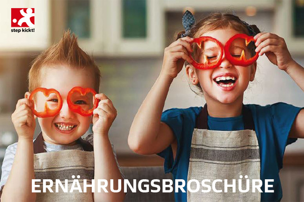 Zwei fröhliche Kinder halten rote Tomatenscheiben vor die Augen wie eine Brille. Im Hintergrund ist eine Küche zu sehen und am unteren Bildrand der Schriftzug 