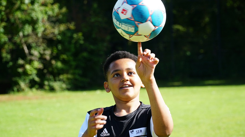 Ein Junge dreht den Ball auf dem Zeigefinger.