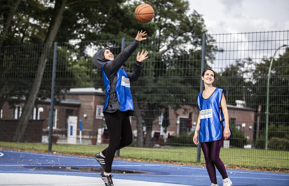 Zwei Mädels spielen Basketball.
