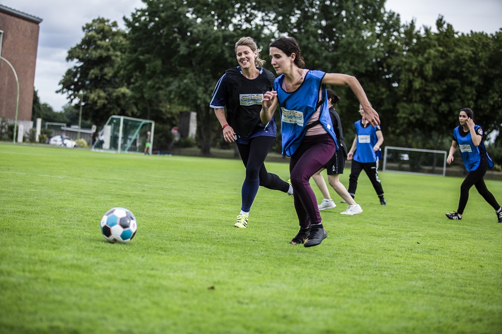 Junge Frauen spielen Fußball auf dem Fußballfeld.