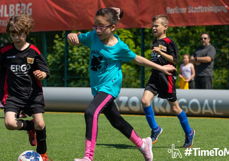 "Logo des Kölner KinderSportFest mit zwei lächelnden Kinderköpfen in Gelb und Orange"