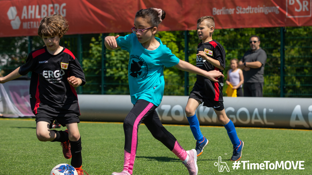 "Logo des Kölner KinderSportFest mit zwei lächelnden Kinderköpfen in Gelb und Orange"