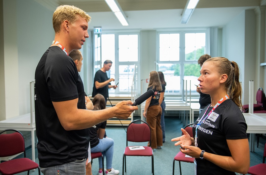Ein Teilnehmer interviewt eine Teilnehmerin.