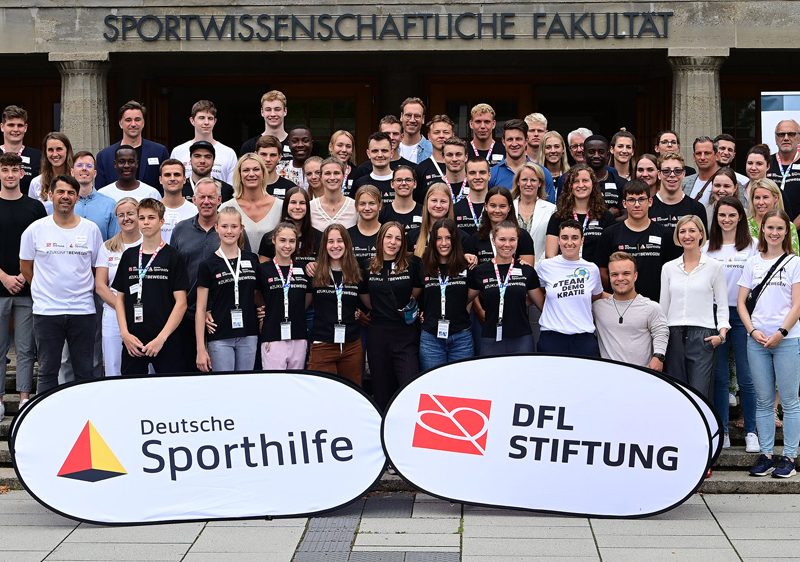 Ein Gruppenbild mit Aufstellern der Deutschen Sporthilfe und der DFL Stiftung.