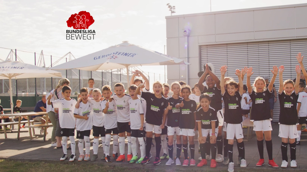 Auf dem Foto sind mehrere Kinder in Sportkleidung nebeneinander zu sehen. Sie jubeln.