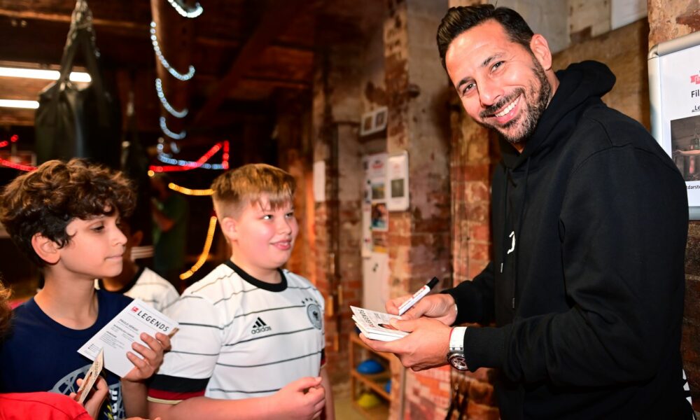 Claudio Pizarro erfüllt die Autogrammwünsche der Kinder.