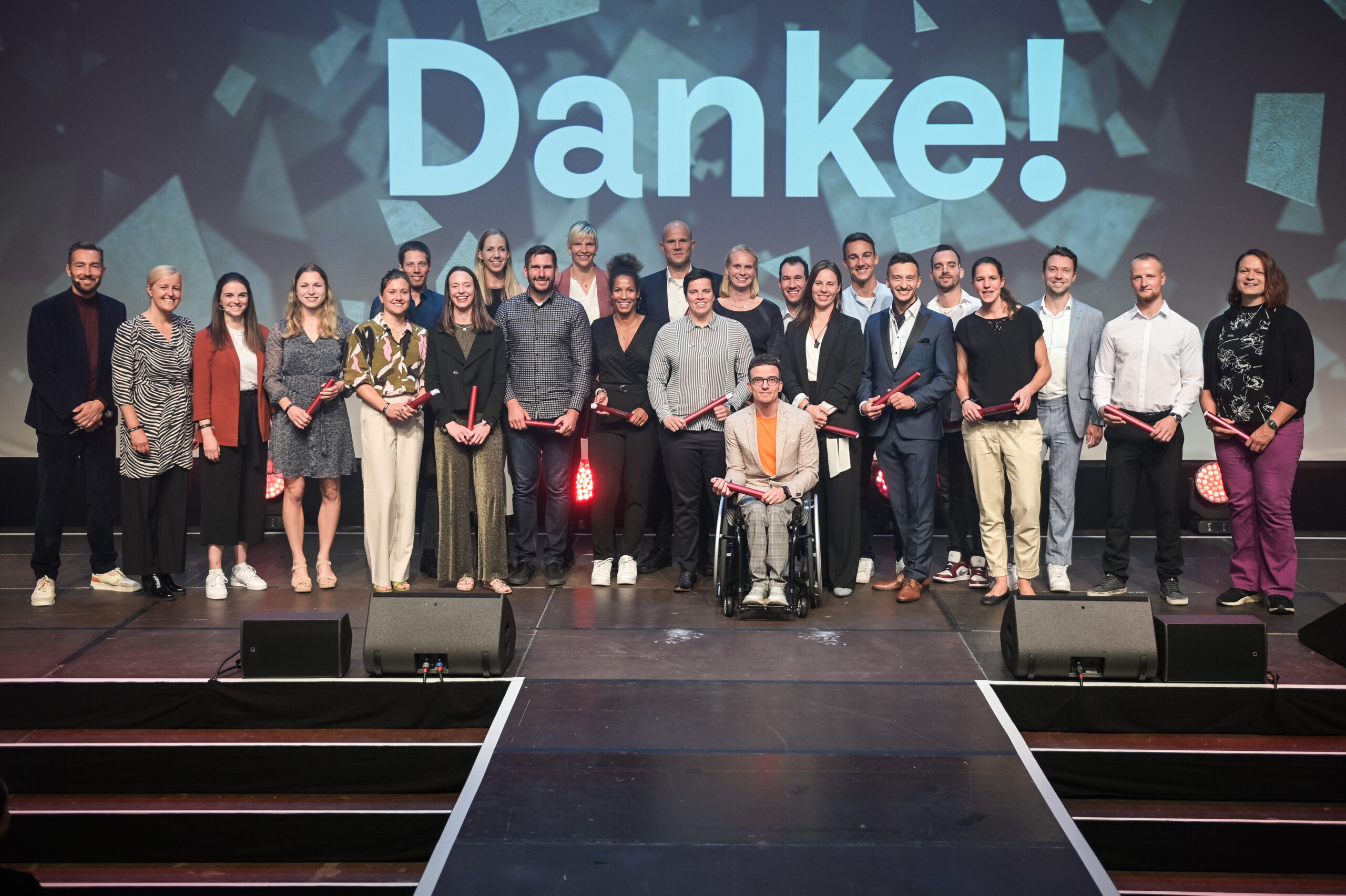 Gruppe von jungen Sportler:innen und Betreuer:innen auf der Bühne bei der Ehrung der "Sporthilfe Juniorsportler:in 2023" in Düsseldorf. Im Hintergrund steht groß "Danke!".