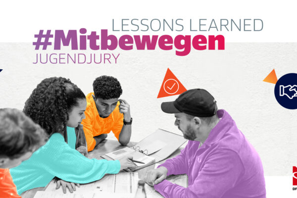 Eine Gruppe junger Menschen sitzt um einen Tisch und diskutiert. Ein erwachsener Mann in blauem Pullover ist ebenfalls dabei. Im Hintergrund steht der Hashtag 