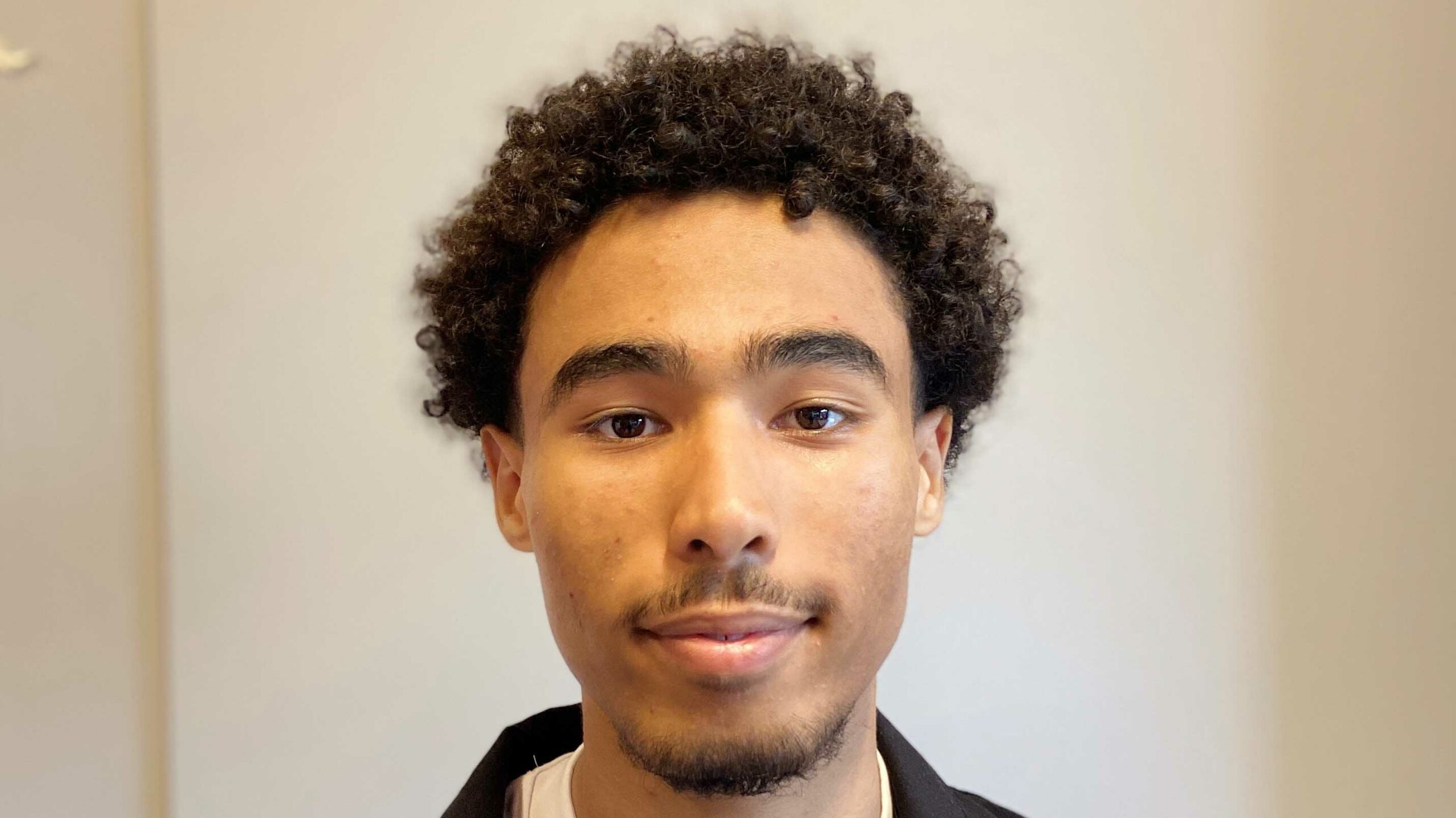 Ibrahim Hassan, Porträt eines jungen Mannes mit lockigem Haar.